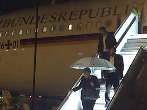 In this Nov. 29, 2018 photo German chancellor Angela Merkel leaves the government Airbus which was grounded after a technical failure at the airport in Cologne, western Germany, delaying Merkel's arrival at the G20 summit in Buenos Aires.