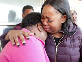 In this Tuesday, Nov. 20, 2018 photo Bernice Parks, left, mother of Sandra Parks, is consoled by Jasmine Wells, centre, Sandra's godmother.