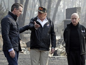 In this Nov. 17, 2018 file photo, President Donald Trump talks with Gov.-elect Gavin Newsom, left, as California Gov. Jerry Brown listens during a visit to a neighbourhood impacted by the Camp wildfire in Paradise, Calif.
