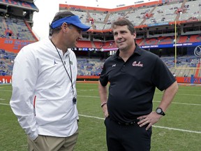 Florida head coach Dan Mullen, left, and South Carolina head coach Will Muschamp greet each other before an NCAA college football game, Saturday, Nov. 10, 2018, in Gainesville, Fla.