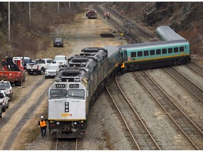 Workers examine the tracks after several VIA rail passenger cars derailed in Halifax on Sunday, Nov. 25, 2018.