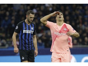 Barcelona forward Luis Suarez, right, reacts after missing a scoring chance during the Champions League group B soccer match between Inter Milan and Barcelona at the San Siro stadium in Milan, Italy, Tuesday, Nov. 6, 2018.