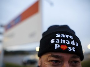 A postal worker wears a "Save Canada Post" hat during a Canadian Union of Postal Workers (CUPW) strike in front of the Gateway Postal facility in Toronto.
