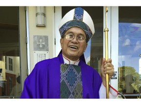 FILE - In this November 2014 file photo, Archbishop Anthony Apuron stands in front of the Dulce Nombre de Maria Cathedral Basilica in Hagatna, Guam. Guam's Catholic church announced Wednesday, Nov. 7, 2018 that it will file for bankruptcy _ a move that lawyers say will allow the archdiocese to avoid trial in dozens of lawsuits alleging child sexual abuse by priests and move toward settlements. The U.S. territory, where almost everyone is Catholic, has been ripped apart by claims the archbishop and other priests abused children. Apuron has denied allegations he molested multiple altar boys.