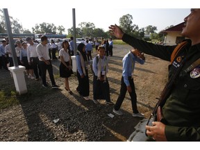 A court security officer, right, guides student as they enter into the courtroom before the hearings against two former Khmer Rouge senior leaders, at the U.N.-backed war crimes tribunal on the outskirts of Phnom Penh, Cambodia, Friday, Nov. 16, 2018. The U.N.-backed tribunal judging the criminal responsibility of former Khmer Rouge leaders for the deaths of an estimated 1.7 million Cambodians will issue verdicts Friday in the latest -- and perhaps last -- of such trials.