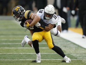 Iowa wide receiver Nick Easley tries to break a tackle by Northwestern defensive back Cameron Ruiz (18) after making a reception during the first half of an NCAA college football game, Saturday, Nov. 10, 2018, in Iowa City, Iowa.