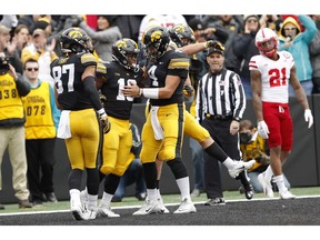 Iowa running back Mekhi Sargent (10) celebrates with teammates Noah Fant, left, and Nate Stanley (4) after scoring on a 15-yard touchdown run during the first half of an NCAA college football game against Nebraska, Friday, Nov. 23, 2018, in Iowa City, Iowa.