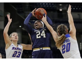 Notre Dame's Arike Ogunbowale, center, goes to the basket between DePaul's Dee Bekelja, left, and Kelly Campbell during the first half of an NCAA college basketball game, Saturday, Nov. 17, 2018, in Chicago.