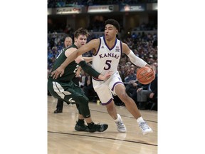 Kansas guard Quentin Grimes (5) goes around Michigan State guard Matt McQuaid (20) in the second half of an NCAA college basketball game at the Champions Classic in Indianapolis on Tuesday, Nov. 6, 2018. Kansas won 92-87.