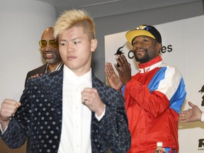 Floyd Mayweather, right, of the U.S. claps as Japanese kickboxer Tenshin Nasukawa strikes a pose during a press conference in Tokyo, Monday, Nov. 5, 2018.