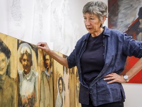 Artist Bev Tosh, the daughter of a Royal New Zealand Air Force pilot and his Canadian war bride, has painted over 150 war bride portraits and looks through some at her studio in Calgary, Alta., Thursday, Nov. 1, 2018.THE CANADIAN PRESS/Jeff McIntosh