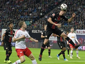 Leverkusen's Sven Bender, right, challenges for the ball against Leipzig's Lukas Klostermann, 2nd left, during the German first division Bundesliga soccer match between RB Leipzig and Bayer 04 Leverkusen in Leipzig, Germany, Sunday, Nov. 11, 2018.