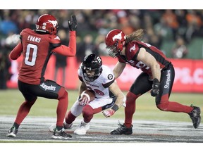 Calgary Stampeders defensive back Ciante Evans (0) and Stampeders linebacker Alex Singleton (49) try and stop Ottawa Redblacks wide receiver Brad Sinopoli (88) during the second half of the 106th Grey Cup in Edmonton, Alta. Sunday, Nov. 25, 2018.