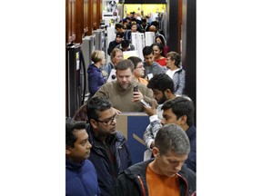 People line up to pay for their purchases as they shop during an early Black Friday sale at a Best Buy store on Thanksgiving Day Thursday, Nov. 22, 2018, in Overland Park, Kan.