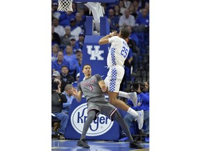 Southern Illinois guard Marcus Bartley (3) takes a charge from Kentucky forward PJ Washington (25) during the first half of an NCAA college basketball game in Lexington, Ky., Friday, Nov. 9, 2018.