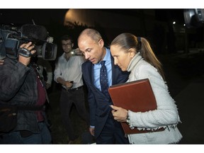 FILE - In this Wednesday, Nov. 14, 2018, file photo, attorney Michael Avenatti, left, leaves the Los Angeles Police Department Pacific Division after posting bail for a felony domestic violence charge. Los Angeles prosecutors have declined to charge Avenatti with a felony for allegedly abusing his girlfriend. The Los Angeles district attorney's office said Wednesday, Nov. 21, it referred the case to city prosecutors to consider misdemeanor charges. Avenatti was arrested on a felony domestic violence charge last week after his girlfriend told police he roughed her up at his apartment.