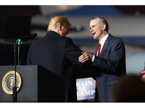 FILE - In this Oct. 18, 2018 file photo President Donald Trump and Montana State Auditor Matt Rosendale, who is running against Sen. Jon Tester, D-Mont., shake hands during a campaign rally at Minuteman Aviation Hangar in Missoula, Mont. Rosendale has President Donald Trump and other big-name Republicans surrounding him on the campaign trail.