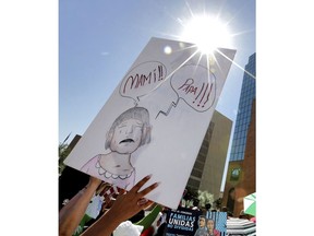 FILE - In this Tuesday, June 26, 2018, file photo, people protest immigration separation policies outside Federal Court in El Paso, Texas. Cases of children and families seeking refuge were being heard inside the courthouse. Half a dozen families who were separated from their children at the U.S.-Mexico border are still detained in Texas months after reuniting with their children. Many families had spent months apart after President Donald Trump's administration launched a zero-tolerance policy requiring anyone who crossed the border illegally to face criminal charges.