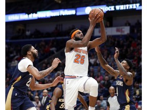 New York Knicks center Mitchell Robinson (26) goes to the basket between New Orleans Pelicans forward Anthony Davis and guard Elfrid Payton (4) in the first half of an NBA basketball game in New Orleans, Friday, Nov. 16, 2018.