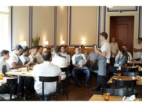 In this Aug. 23, 2018, photo Timmy Harris, a cook, gives a presentation on existentialism to co-workers at Alon Shaya's restaurant Saba in New Orleans. Shaya, an award-winning New Orleans chef, used to head three restaurants that were part of the Besh Restaurant Group. But about a year ago allegations of sexual misconduct at several of the restaurants contributed to an acrimonious split. Now Shaya has started a new restaurant venture, Pomegranate Hospitality, with his wife which includes restaurants in New Orleans and Denver.