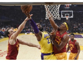 Los Angeles Lakers forward LeBron James, center, shoots as Indiana Pacers forward Bojan Bogdanovic, left, of Croatia, and center Myles Turner defend during the first half of an NBA basketball game Thursday, Nov. 29, 2018, in Los Angeles.