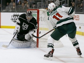 Los Angeles Kings goaltender Jack Campbell, left, deflects a shot by Minnesota Wild left wing Zach Parise during the first period of an NHL hockey game in Los Angeles, Thursday, Nov. 8, 2018.