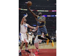 Golden State Warriors forward Draymond Green, right, shoots as Los Angeles Clippers center Marcin Gortat, of Poland, defends during the first half of an NBA basketball game Monday, Nov. 12, 2018, in Los Angeles.
