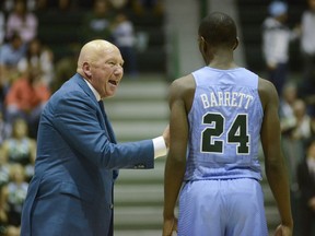 Tulane head coach Mike Dunleavy Sr., left, talks to guard Shakwon Barrett (24) during the first half of an NCAA college basketball game against Florida State in New Orleans, Sunday, Nov. 11, 2018.