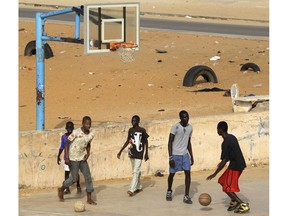 FILE - In this Aug. 7, 2010 file photo, soccer and basketball games overlap as boys share space on a basketball court local residents say was built several years ago by Charlotte Bobcats' Dasagana Diop in the neighborhood where he grew up in Dakar, Senegal. The NBA has big plans for Africa where an office was established eight years ago in South Africa and there's an annual exhibition game featuring NBA stars.