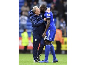 Cardiff City manager Neil Warnock, left, embraces winning goal scorer Sol Bamba after the English Premier League soccer match between Cardiff City and Brighton and Hove Albion at the Cardiff City Stadium, Cardiff, Wales. Saturday Nov. 10, 2018.