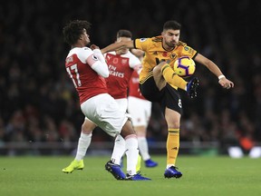 Arsenal's Alex Iwobi, left, and Wolverhampton Wanderers' Ruben Neves in action during their English Premier League soccer match at the Emirates Stadium in London, Sunday Nov. 11, 2018.