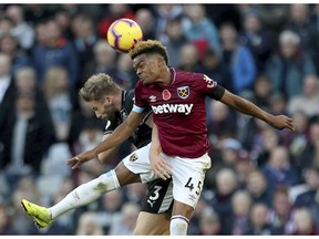 West Ham United's Grady Diangana, right, and Burnley's Charlie Taylor jump for the ball during the English Premier League soccer match between West Ham United and Burnley at The London stadium, London. Saturday Nov. 3 2018 |