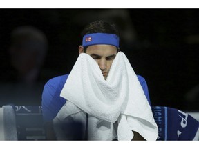 Roger Federer of Switzerland wipes his face with a towel during his ATP World Tour Finals singles tennis match against Alexander Zverev of Germany at the O2 Arena in London, Saturday Nov. 17, 2018.