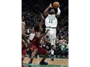 Boston Celtics guard Kyrie Irving (11) shoots over Cleveland Cavaliers guard Collin Sexton (2) during the first half of an NBA basketball game Friday, Nov. 30, 2018, in Boston.