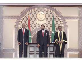 President elect Ibrahim Mohamed Solih, left, stands to take oath of office, administered by Chief Justice Dr Ahmed Abdulla Didi, right, in Male, Maldives, Saturday, Nov. 17, 2018. Thousands of people cheered Solih, from the Maldivian Democratic Party, at a swearing-in ceremony Saturday in a soccer stadium chosen to accommodate a large number of his supporters.