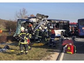 Firefighters stand next to buses crashed in Ammerndorf near Fuerth, Germany, Thursday, Nov. 15, 2018.  15.11.2018. Police say 40 adults and children have been injured, five of them "very seriously," after two public buses collided.