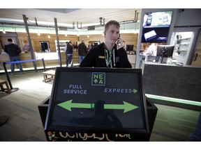 In this Wednesday, Oct. 17, 2018 photo New England Treatment Access medical marijuana dispensary employee Tyler Mize, of Orange, Mass., speaks on a phone near an entryway to the dispensary, in Northampton, Mass. Within days perhaps, the medical marijuana dispensary in Northampton expects to receive the final go-ahead to throw its doors open to anyone 21 or older who wants to purchase cannabis products ranging from flower to edibles, creams and even suppositories.