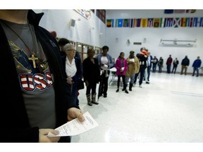 People wait in line at polling place during election day, Tuesday, Nov. 6, 2018, in Silver Spring, Md.