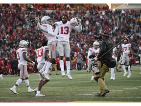 Ohio State cornerbacks Tyreke Johnson (13) and Kendall Sheffield, left center, celebrate after an NCAA football game against Maryland, Saturday, Nov. 17, 2018, in College Park, Md. Ohio State won 52-51 in overtime.