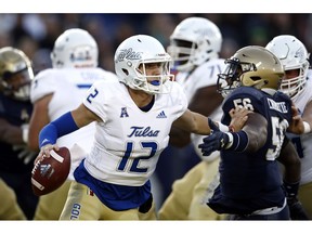 Tulsa quarterback Seth Boomer (12) pushes off Navy linebacker Nizaire Cromartie as he looks for a receiver in the first half of an NCAA college football game, Saturday, Nov. 17, 2018, in Annapolis, Md.