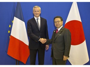 France's Finance Minister Bruno Le Maire, left, welcomes Japan's Economy, Trade and Industry Minister Hiroshige Seko prior to a meeting in Paris, France, Thursday, Nov. 22, 2018. Nissan's board will meet Thursday to decide whether to dismiss its chairman Carlos Ghosn following his arrest on suspicion of underreporting his income