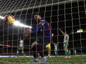 FC Barcelona's Lionel Messi collects a ball from the net after scoring a penalty during the Spanish La Liga soccer match between FC Barcelona and Betis at the Camp Nou stadium in Barcelona, Spain, Sunday, Nov. 11, 2018.