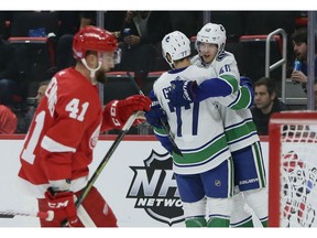 Vancouver Canucks center Elias Pettersson (40), of Sweden, celebrates his first period goal with right wing Nikolay Goldobin (77), of Russia, as Detroit Red Wings center Luke Glendening (41) skates away during an NHL hockey game Tuesday, Nov. 6, 2018, in Detroit.