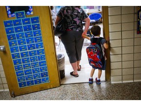FILE - In this Sept. 8, 2015 file photo, a reluctant student is pulled into the first day of kindergarten at an elementary School in Clio, Mich. A study shows the youngest children in a classroom are more likely to be diagnosed with attention deficit hyperactivity disorder. It's an intriguing finding for parents considering what's called "kindergarten redshirting," or delaying school entry. Researchers say doctors should be aware of how classroom comparisons shape diagnosis. The paper was published Wednesday, Nov. 28, 2018, by the New England Journal of Medicine. (Christian Randolph/The Flint Journal via AP, File)