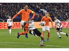 Netherland's Virgil Van Dijk, left, and Germany's Thomas Mueller challenge for the ball during the UEFA Nations League soccer match between Germany and The Netherlands in Gelsenkirchen, Monday, Nov. 19, 2018.
