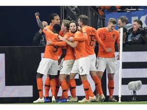Netherland's Virgil Van Dijk is celebrated by his team after scoring his side's second goal in the 90th minute during the UEFA Nations League soccer match between Germany and The Netherlands in Gelsenkirchen, Monday, Nov. 19, 2018. The match ended 2-2.