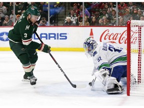 Minnesota Wild center Charlie Coyle (3) is stopped by Vancouver Canucks goalie Richard Bachman (25) during the first period of an NHL hockey game Thursday, Nov. 15, 2018, in St. Paul, Minn.