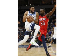 Minnesota Timberwolves' Karl-Anthony Towns, left, drives on New Orleans Pelicans' Julius Randle during the first half of an NBA basketball game Wednesday, Nov. 14, 2018, in Minneapolis.