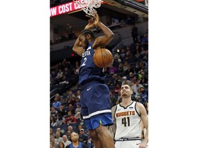 Minnesota Timberwolves' Andrew Wiggins, left, dunks as Denver Nuggets' Juancho Hernangomez watches during the first half of an NBA basketball game Wednesday, Nov. 21, 2018, in Minneapolis.