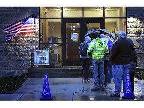 A line of voters waits for the polls to open outside St. Joseph the Worker Catholic Church, Tuesday, Nov. 6, 2018, in Mankato, Minn.